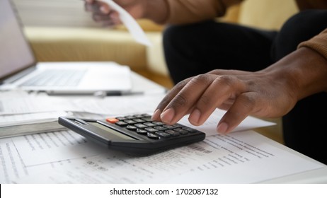 Close Up Black Man Hand Using Calculator And Laptop For Calculating Finance. African American Businessman Taxing, Accounting, Statistics And Credit Analytic For Mortgage Payment.