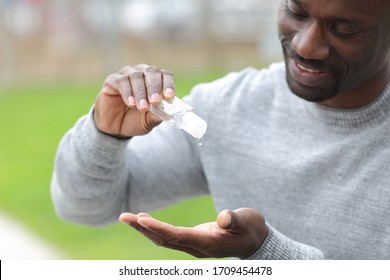 Close Up Of Black Man Using Hand Sanitizer Rub Standing In A Park