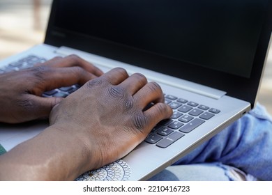 Close Up Of Black Man Working Remotely With A Laptop