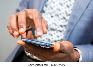 close up of a black man's hand operating a mobile phone