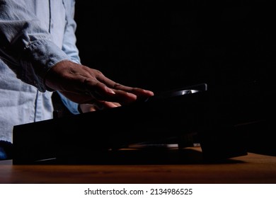 Close Up Of A Black Man's Hand Over A DJ Console Against A Black Background. African American Man Playing Loud Popular Music In A Club On Professional Music Equipment