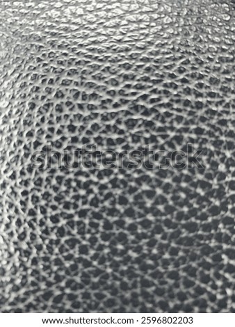 Close - up black peppled leather texture background. Highly detailed macro shot of a black peppled leather surface. This versatile texture is perfect for backgrounds, print materials, and web design. 