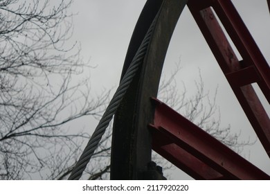 Close up of black and red metal wheel with steel cable, originally used in a salt mine's winding tower (horizontal), Bad Salzdetfurth, Lower Saxony, Germany