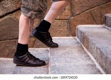 Close Up Of Black Sneaker Feet Walking Up Stairs.