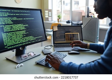 Close Up Of Black Software Developer Writing Code At Workplace In Office With Multiple Devices