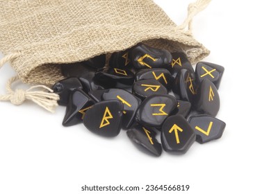 Close up of black stone runes with burlap sack isolated on white background. - Shutterstock ID 2364566819