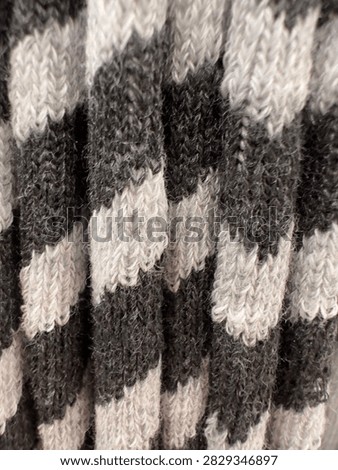 Close up of black white and gray knitted textile texture creating abstract cozy background for fashion design, fabric, packaging, wallpaper and digital projects.