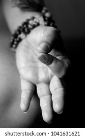 Close Up Black And  White Of A Hand Wearing A Beaded Bracelet, Held In A Way Typically Associated With Yoga, Meditation, Relaxation And A Calm Mood Or Spirit, Free From The Struggle Of Daily Life.