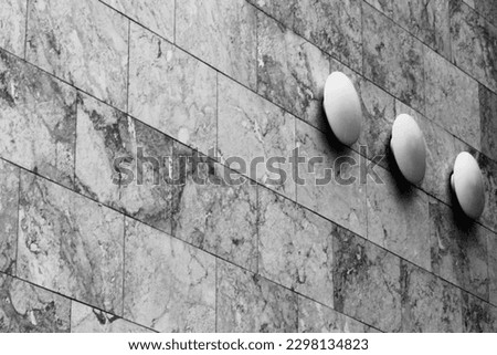 Close up black and white image of a stone building with 3 modern metal decorations in Mainz, Germany