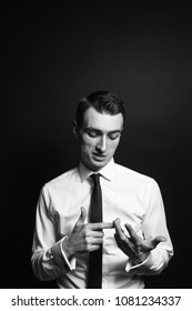 Close Up Black And White Portrait Of A Young Man In A White Shirt And Black Tie, Counting With His Fingers And Talking, Against A Plain Studio Background