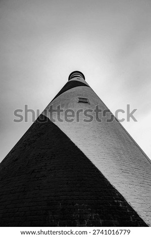 Up close Black and White vertical view of Cape Lookout lighthouse with a cloudless sky
