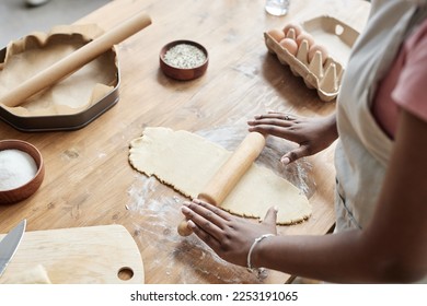 Close up of black woman baking homemade pastry and rolling dough on wooden kitchen counter, copy space - Powered by Shutterstock