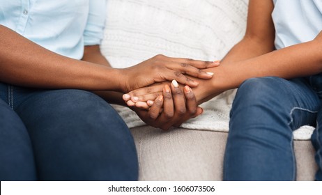 Close Up Black Woman And Child Sitting On Couch Holding Hands, Saying Sorry, Apologize