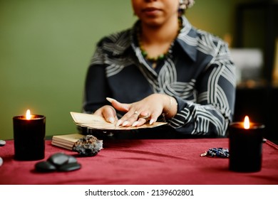 Close Up Of Black Woman Reading Tarot Cards In Fortune Tellers Shop Lit By Candles, Copy Space