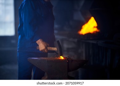 Close Up Of Blacksmith Hands Hitting With Hammer On Glowing Hot Metal. Man Processing Metal On Anvil At Forge. Manual Production. 