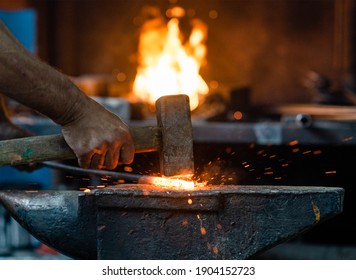 Close up blacksmith working metal with hammer on the anvil in the forge - Powered by Shutterstock