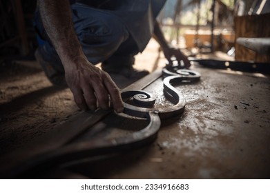 Close up of a blacksmith's hands checking the measurements of a grating in his workshop. Blacksmith concept. - Powered by Shutterstock