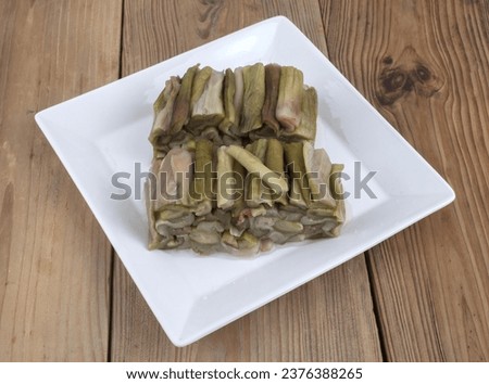 Close up of blanched taro stalk with cross section on white dish and wood floor, South Korea
