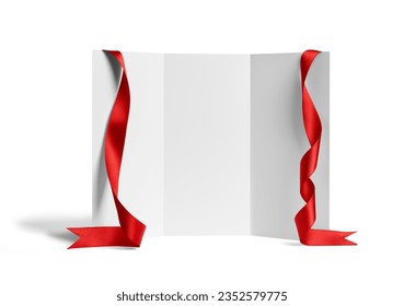 close up of a  blank folded leaflet or a desktop calendar with ribbon on white background 