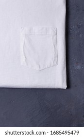 Close Up Blank White Tshirt On Grey Concrete Background With Pocket. Mock Up For Branding T-shirt. 