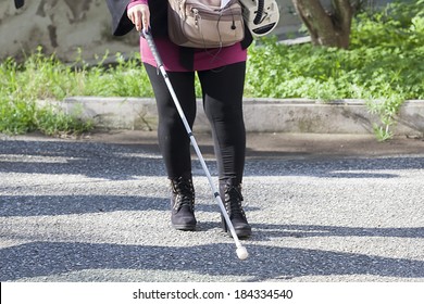 Close up in blind woman's feet with stick