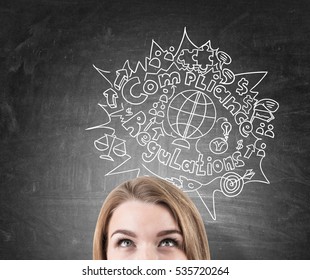 Close Up Of A Blond Woman's Head Near A Blackboard With A Compliance And Regulations Sketch Depicted On It. Concept Of Following The Rules Of International Trade