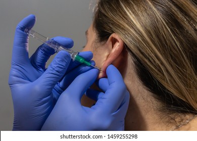 Close Up Of A Blonde Girl Getting Her Ear Pierced 