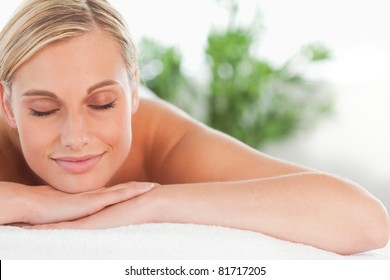 Close up of a blonde smiling woman relaxing on a lounger with eyes closed in a wellness center - Powered by Shutterstock