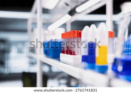 Close up of blood samples in test tubes arranged on laboratory shelf rack. Focus on sanguine fluid specimen containers in clinical laboratory environment used for medical research