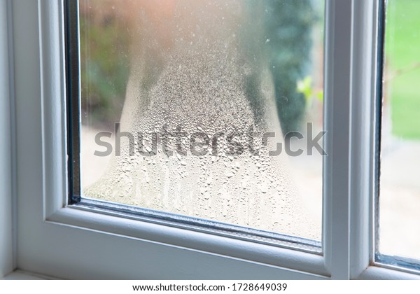 Close up of blown double glazed\
unit. Failed window glazing with condensation inside,\
UK