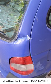 Close Up Of Blue Car Hatch Back Trunk Dented Paint Peeling Off, Scratch And Bird Droppings