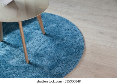 Close Up Of Blue Carpet On Wood Floor With Table