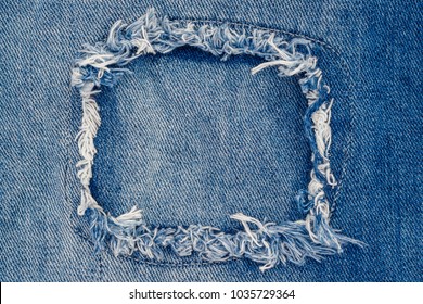Close up blue jean frame. Destroyed torn ripped denim blue jeans patch. 