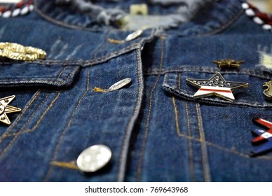 Close up blue jeans jacket decorted with metal button and brooch modern design (Selective focus)