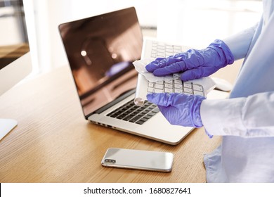 Close up blue latex gloves cleaning surface of workspace equipment with towel. Quarantine at home or office, step of prevention of coronavirus infection spread, sanitizing, disinfection, protection