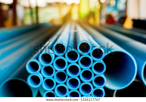 Close up to blue\
plastic pipe background, PVC pipes stacked in warehouse,  PVC water\
pipes used for\
construction