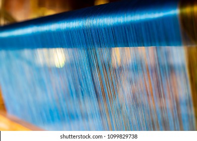 Close Up of Blue Silk on the Weaving machine and Thai traditional Silk. Weaving loom for homemade Silk textile production in Thailand