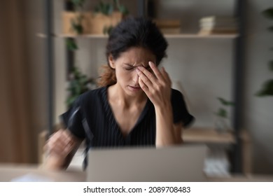 Close Up Blurred Of Sick Unhealthy Latino Woman Suffer From Dizziness Work On Laptop At Home Office. Ill Unwell Tired Hispanic Female Struggle With Migraine Or Headache, Overwhelmed With Screen Job.