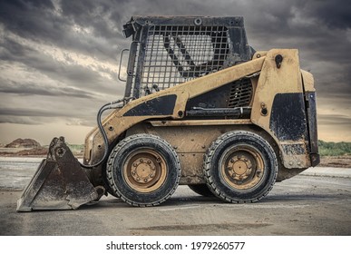 a close up of a bobcat or a skid steer loader used in construction,landscaping and agriculture. It has a many purpose bucket in the front.