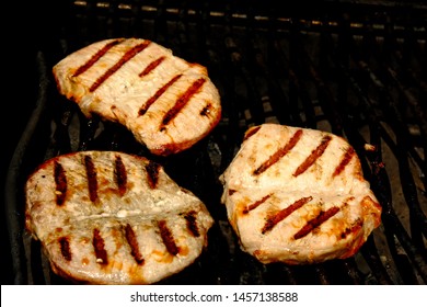 Close Up Of Boneless Pork Chops With Grill Marks On Barbecue. High Angle View