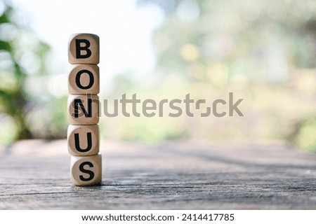 close up bonus wooden text block on table, saving and manage to success business concept