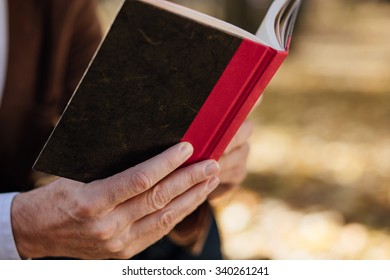 close up of a book in hands of a men