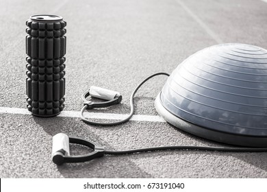 Close Up Of A Bosu Ball On A Running Track. Sport And Fitness Equipment. Foam Roller For Massage And Pilates Ball.