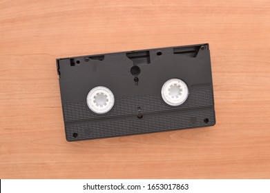 Close Up Of The Bottom Side Of A VHS Tape On Wood Grain Table