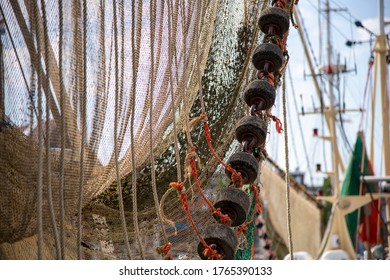 Close Up Of A Bottom Trawl Net With Trawl Ground Gear (disks) Hanging On A Trawler To Dry In The Harbor Of Harlingen In The Netherlands