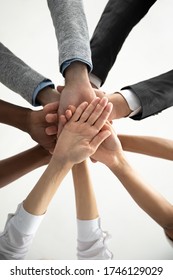 Close Up Bottom View Vertical Photo Diverse Business People Stacking Hands In Pile At Corporate Meeting, Colleagues Employees Engaged In Team Building Activity At Briefing, Celebrating Shared Success