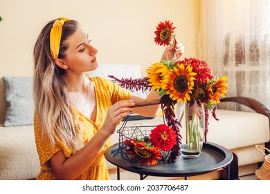 Close Up Of Bouquet Arrangement. Woman Puts Sunflowers And Zinnias In Vase On Table At Home. Fresh Fall Yellow Red Brown Blooms. Interior And Decor