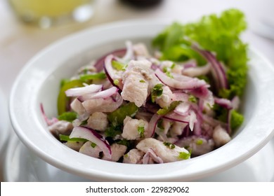 A Close Up Of A Bowl Of Fish Ceviche Salad With Purple Onions.