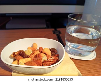 Close Up Of A Bowl Of Nut And Dried Fruit And A Glass Of Water