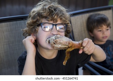 Close Up Of Boy Eating Turkey Leg At Thanksgiving